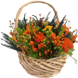 Cesta de flores preservadas con tonos naranja.