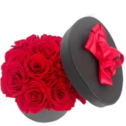 Centro de rosas rojas preservadas hecho en caja negra redonda.
