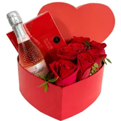 Caja con forma de corazón, rosas rojas y bombones.