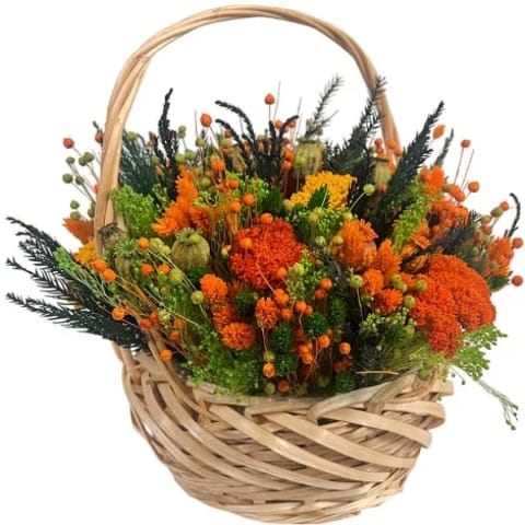 Cesta de flores preservadas con tonos naranja.