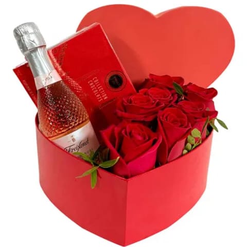 Caja con forma de corazón, rosas rojas y bombones.