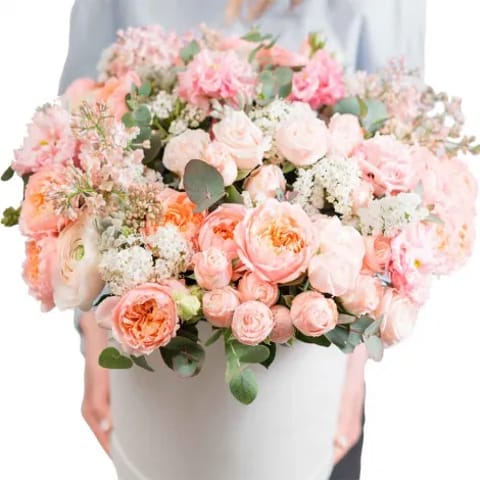 Centro de flores variadas en caja de sombrero